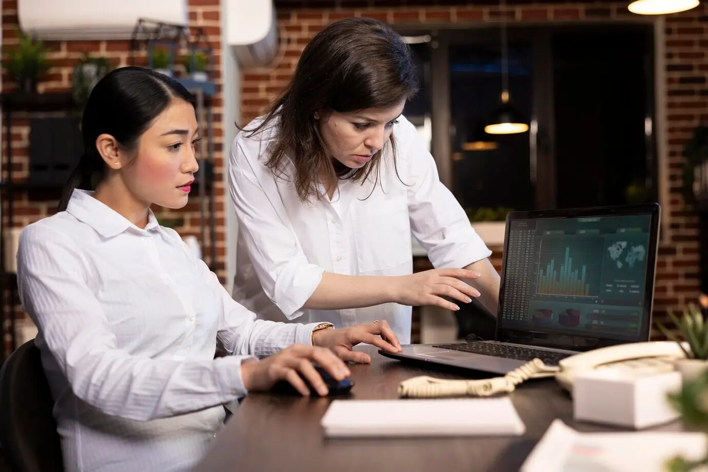 Коллеги анализируют диаграммы на ноутбуке.